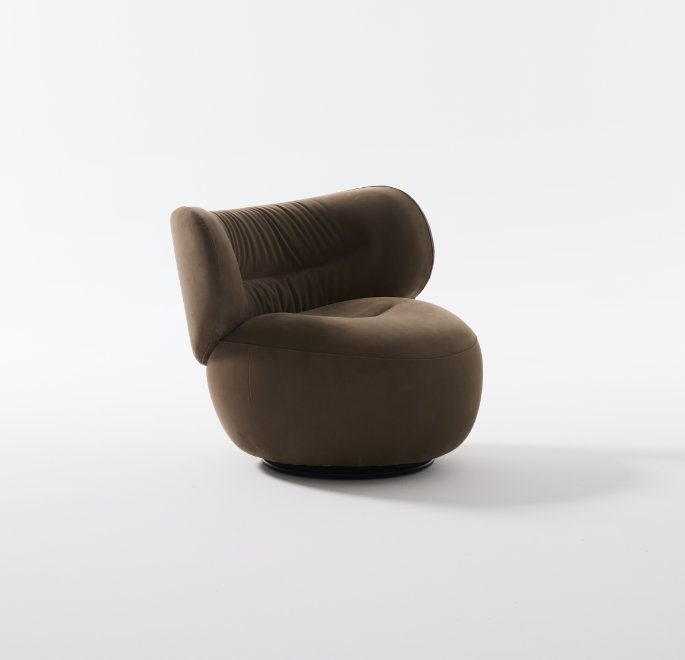 Amelie armchair in a relaxed interior setting highlighting its sculptural presence.