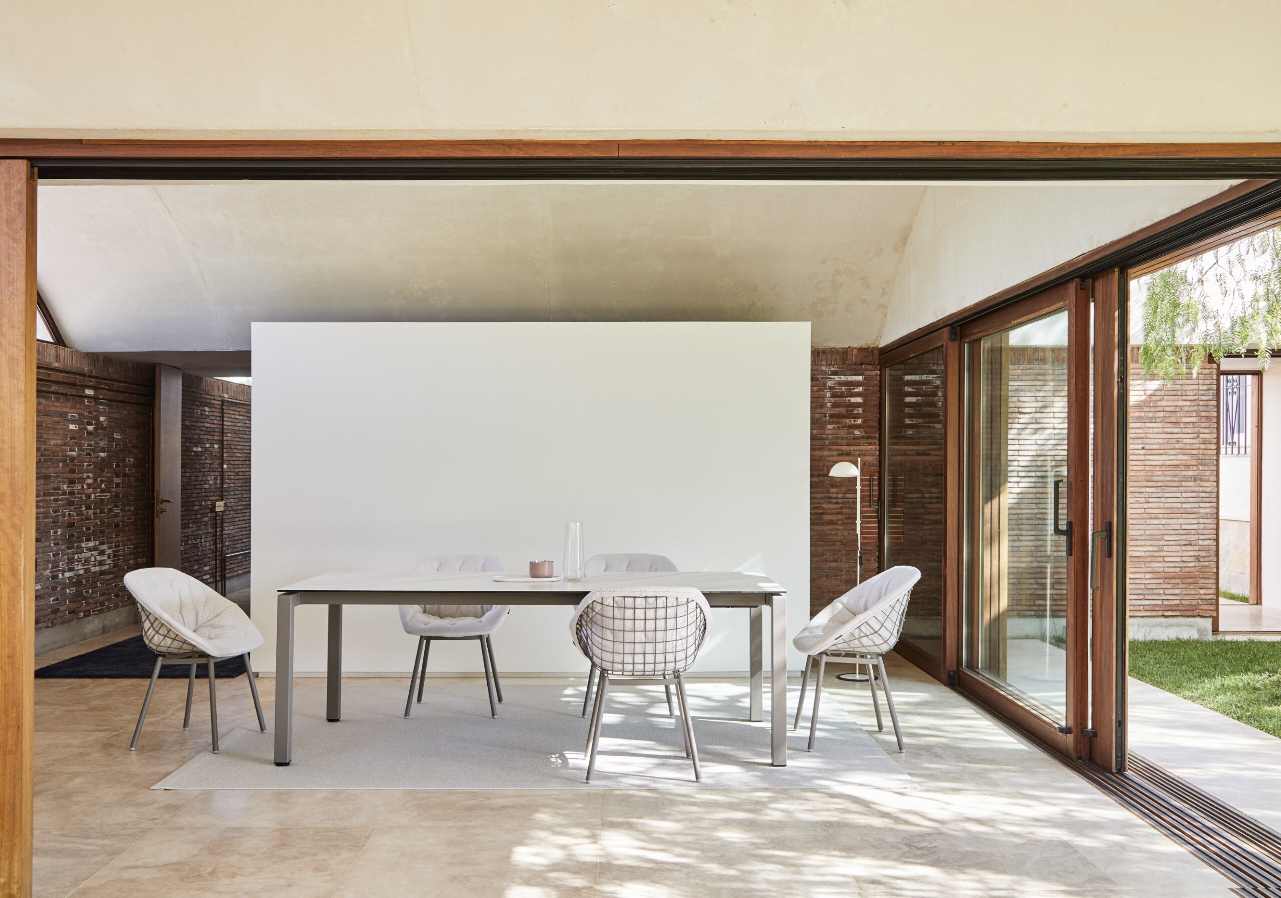 Canasta outdoor chair with woven wire shell in terrace setting
