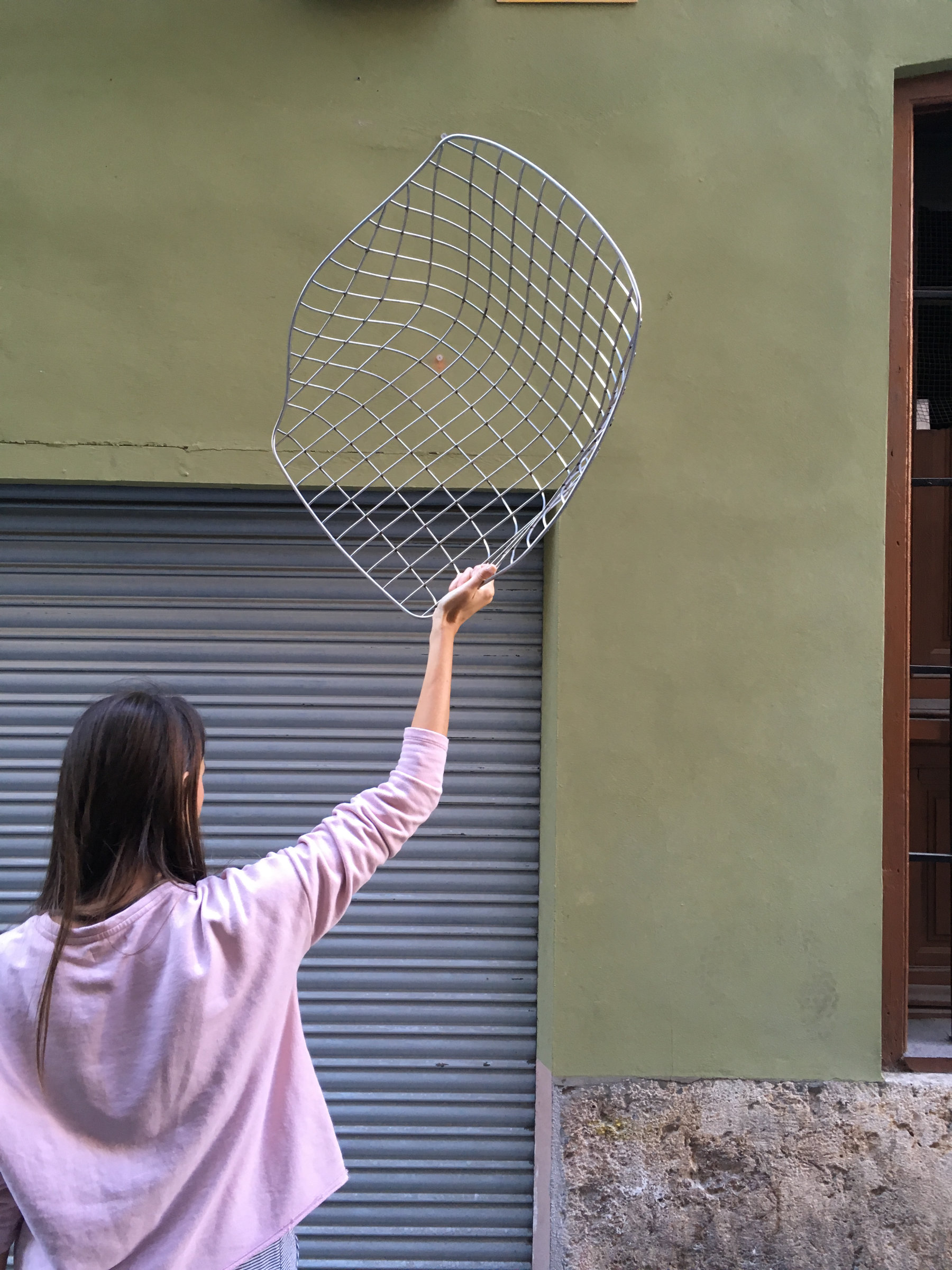 Canasta outdoor chair with woven wire shell in terrace setting
