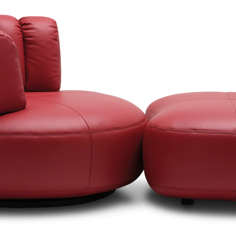 Upholstered lounge chair with circular base and segmented padded backrest, soft sculptural design.
