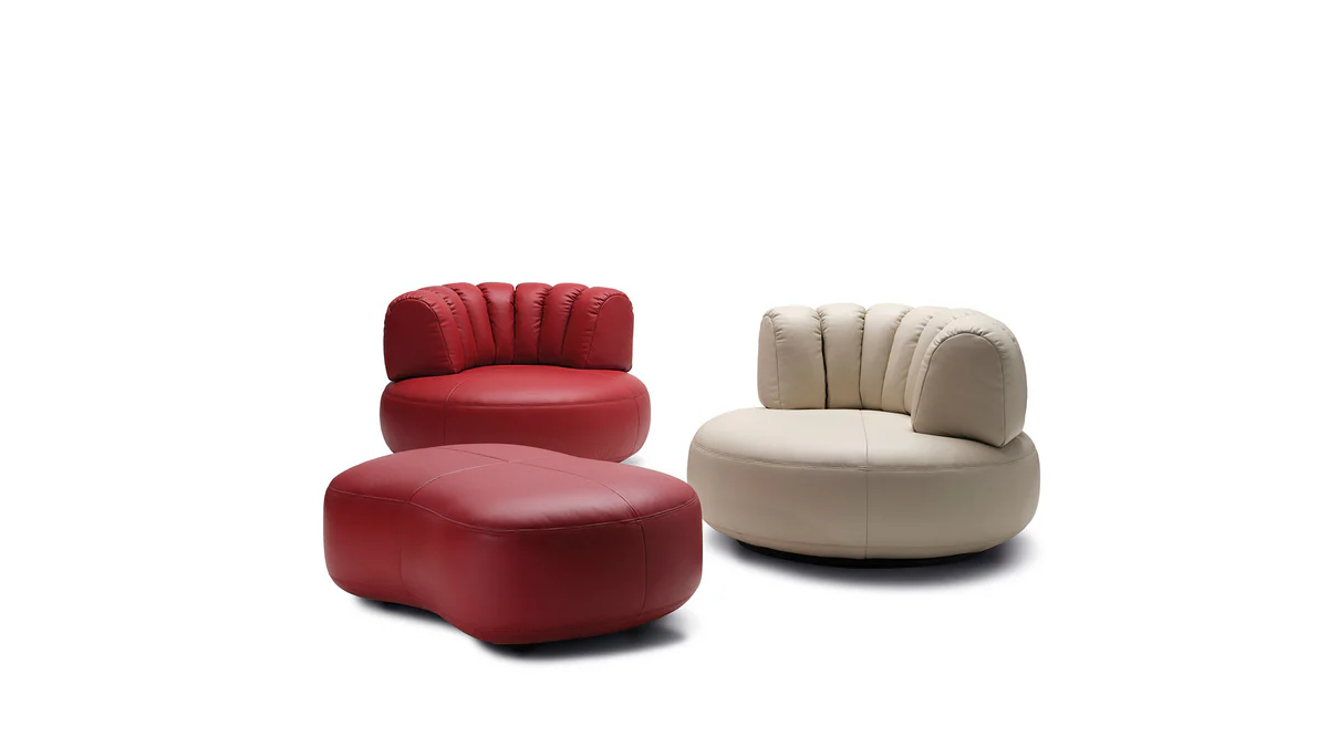 Upholstered lounge chair with circular base and segmented padded backrest, soft sculptural design.