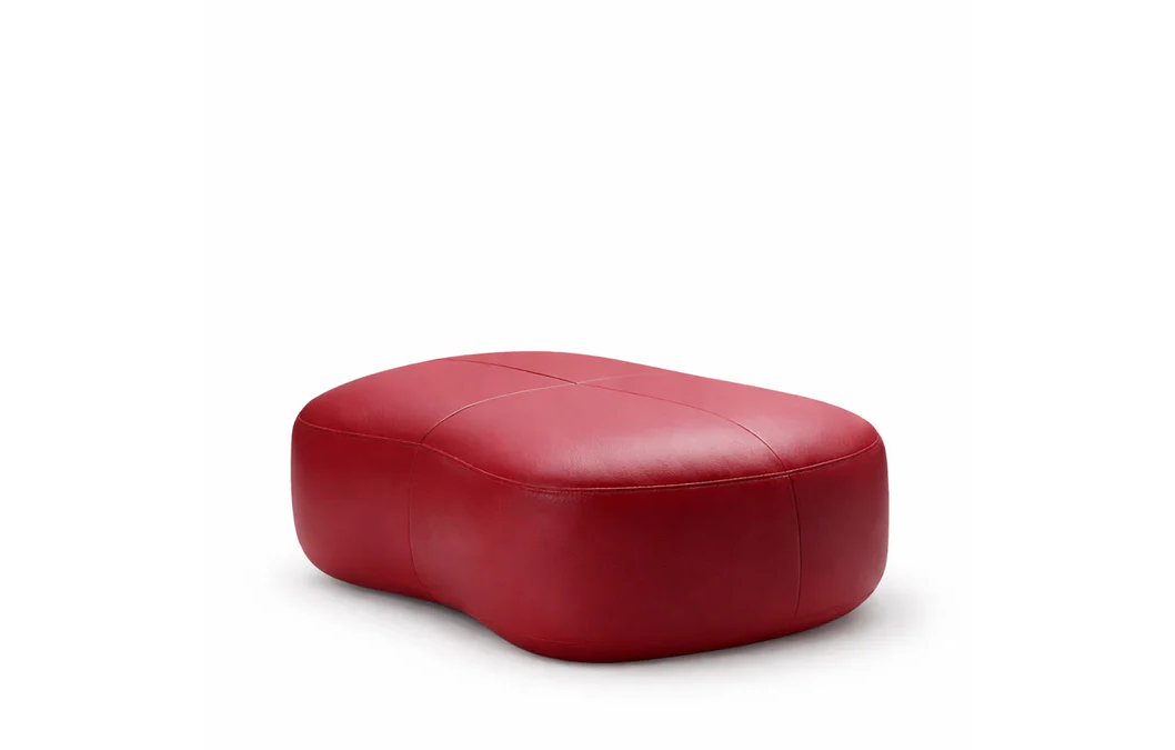 Upholstered lounge chair with circular base and segmented padded backrest, soft sculptural design.