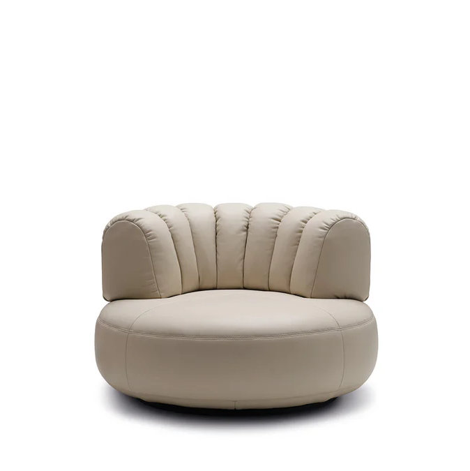 Upholstered lounge chair with circular base and segmented padded backrest, soft sculptural design.